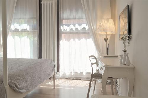 a bedroom with a bed and a desk and a window at BED in BO Saragozza in Bologna