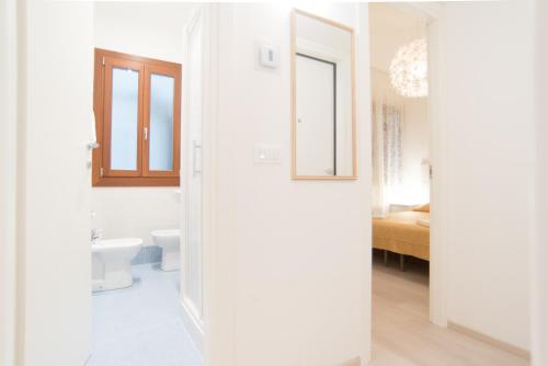 a white bathroom with a toilet and a sink at Lovely in San Marco in Venice