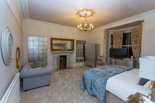 a bedroom with a king sized bed and a fireplace at Trinity Boutique B&B in Peterhead