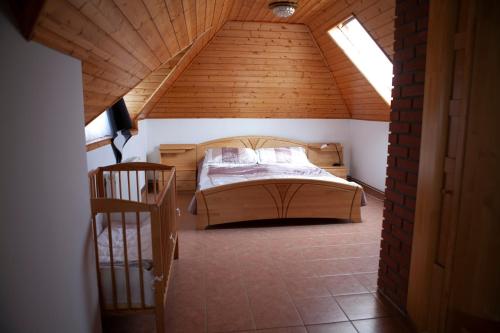 a bedroom with a bed in a attic at Rózsadomb Apartman in Zalakaros