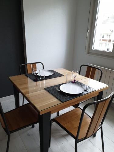 une table en bois entourée de deux chaises dans l'établissement EM LIFE Strasbourg, à Strasbourg