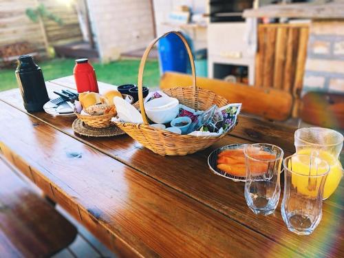 uma mesa de madeira com cestas de comida e bebida sobre ela em Recanto do Xamã - Praia do Rosa em Praia do Rosa