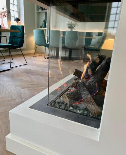 a fireplace in a room with chairs and a table at BUITERLING Hotel in Brilon