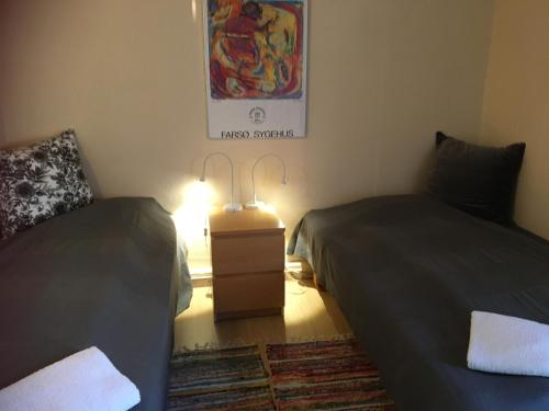 two beds in a room with a lamp between them at Margretelyst in Farsø