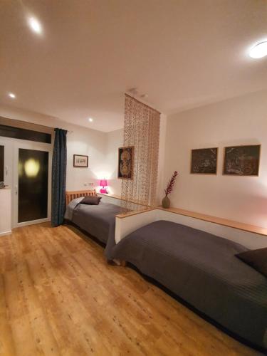 two beds in a bedroom with a wooden floor at Landhaus Warndtwald in Wadgassen
