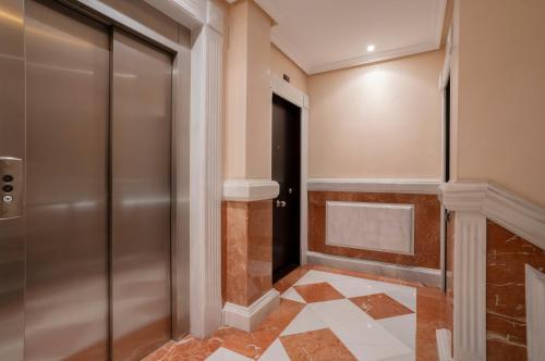 a hallway with a door and a tile floor at DE LA GUARDIA LOFT ROSAL in Oviedo