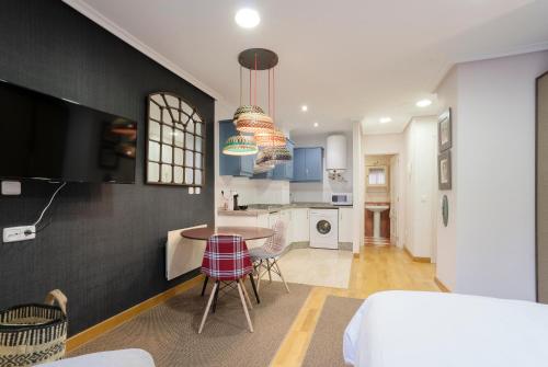 a kitchen and living room with a table and chairs at DE LA GUARDIA LOFT ROSAL in Oviedo