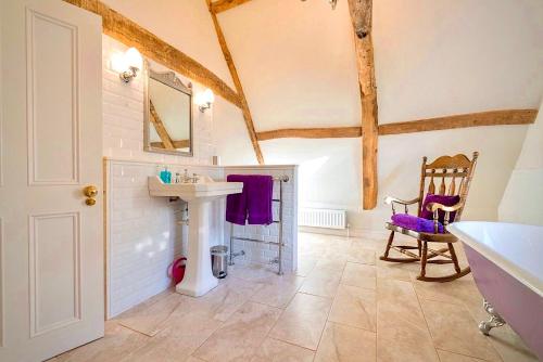 a bathroom with a sink and a mirror and a chair at Swafield Hall in Swafield