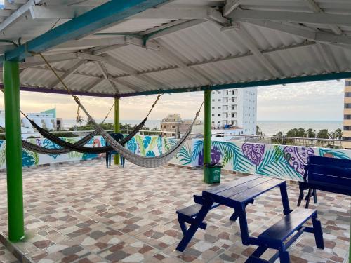 a hammock and benches on a roof with a mural at Hotel Brisas del Nare in Ríohacha