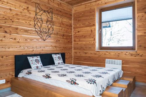 a bedroom with a bed in a log cabin at Flisak in Jaworki