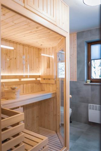a bathroom with wood paneled walls and a toilet at Flisak in Jaworki