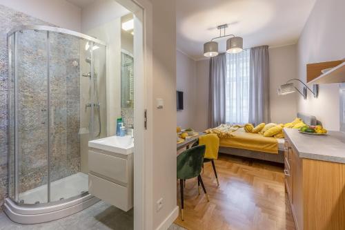 a bathroom with a shower and a bedroom with a bed at Loretańska Apartments 6 in Krakow