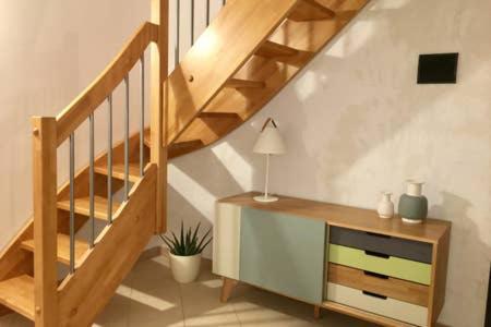 a room with a staircase and a dresser with a lamp at La Casa del Sole in Marina di Pisticci