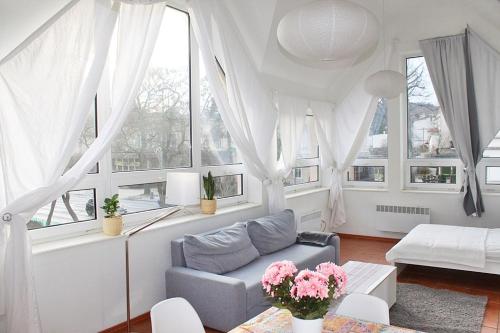 a living room with a couch and some windows at Apartament Central Sopot in Sopot