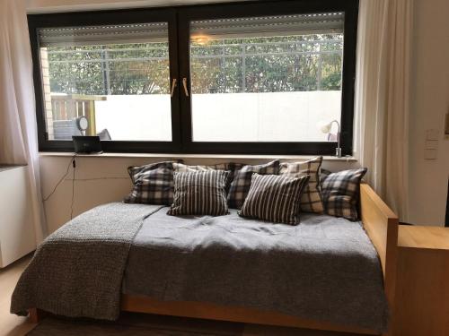 a bedroom with a bed with pillows in front of a window at 2 Room Messe Kongress Stadion in Dortmund