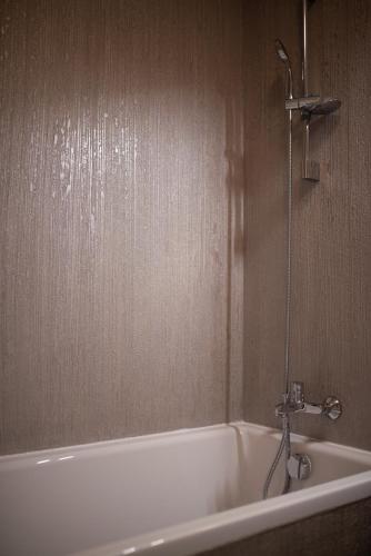 a white bath tub in a bathroom with a shower at Apartament Denissia in Oradea