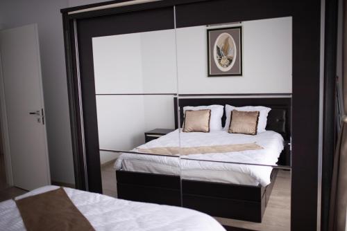two beds in a room with a mirror at Apartament Denissia in Oradea
