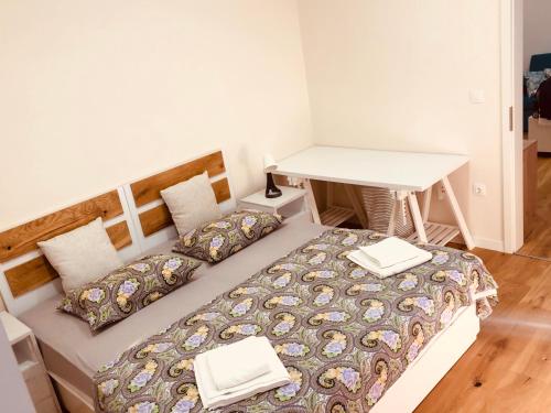 a bedroom with a bed with a table and a desk at Apartment Karin in Rijeka