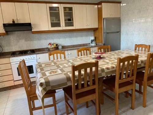 a kitchen with a table and chairs and a refrigerator at Casa Madrileños in Outes