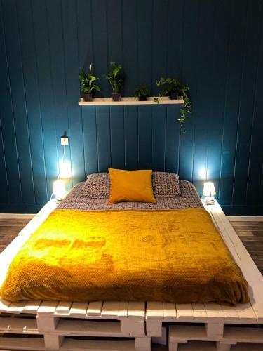 a bedroom with a large bed with a yellow blanket at chambre double avec salle de bain privative in Cognac