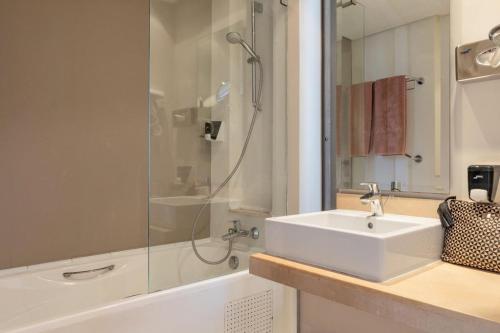 uma casa de banho branca com um lavatório e um chuveiro em Club Palm Azur Families and Couples em Midoun