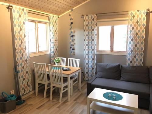 sala de estar con sofá y mesa en Ljusdals Camping en Ljusdal