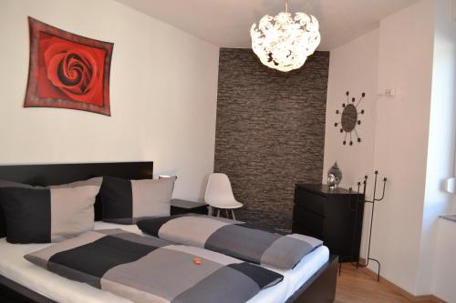 um quarto com uma cama grande e um lustre em FeWo Kleeblatt mit eigener Terrasse em Wuppertal