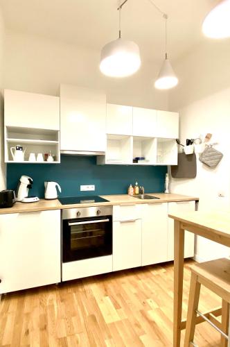 a kitchen with white cabinets and a black oven at Über den Dächern Boppards in Boppard