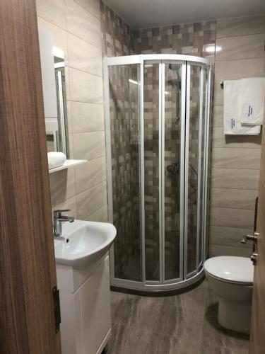 a bathroom with a shower and a sink and a toilet at Apartment FREEDOM in Shkorpilovtsi
