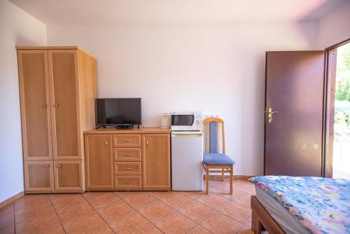 1 dormitorio con 1 cama y vestidor con TV en Kwatery przy plaży en Ustronie Morskie