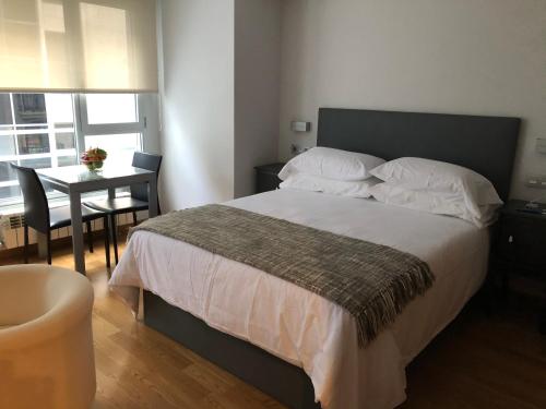 1 dormitorio con 1 cama y 1 mesa con silla en Contemporaneo y Centrico en Vigo