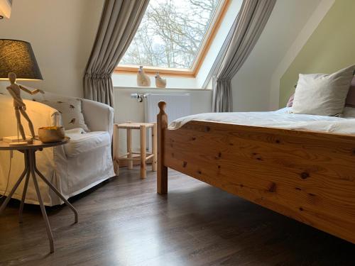 Un dormitorio con una cama grande y una ventana en Loh Apartments - Wald.Natur.Ruhe. en Undeloh