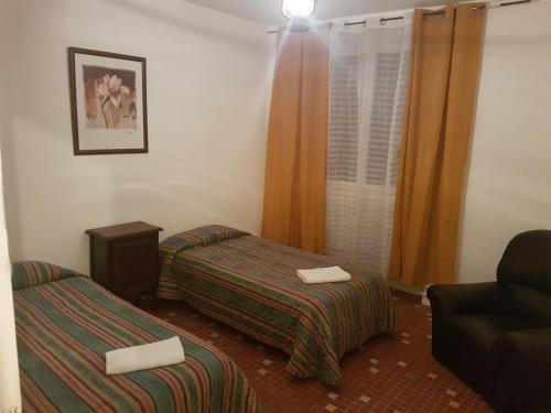 une chambre d'hôtel avec deux lits et une chaise dans l'établissement Maison F4 90m2 au Calme, à Sarrouilles