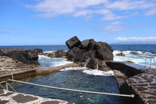 a hot tub on the rocks by the ocean at Adega do Xelica - Holiday Cottage in Arcos
