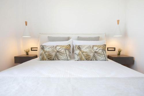a bedroom with a white bed with two night stands at Kouros Village in Antiparos Town