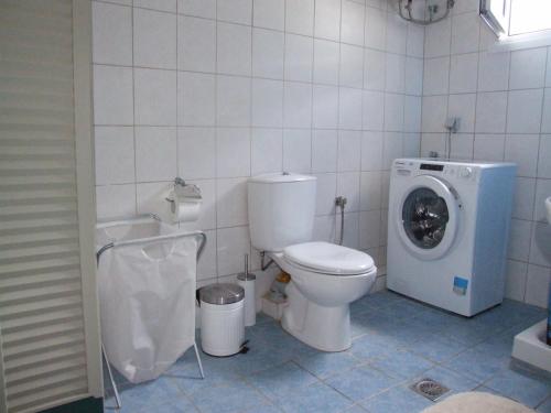 łazienka z toaletą i pralką w obiekcie House by the sea w mieście Chrysi Ammoudia