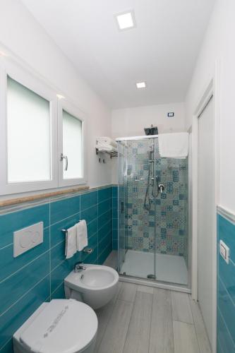 a bathroom with a toilet and a glass shower at Dreams Tropea Mare "Parking Private" in Tropea