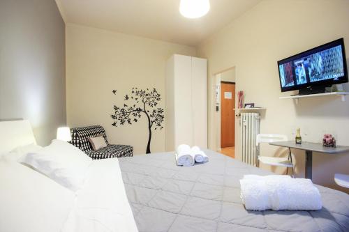 una camera con letto bianco e TV a parete di Le Piazze di Roma Sweet Apartment a Roma