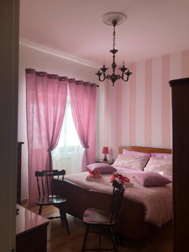 蒂沃利Intero Appartamento dei Pini - posto auto incluso - 4 piano senza ascensore的一间卧室配有一张粉色和白色条纹的床