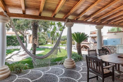 a porch with a hammock and a table and chairs at LA CESA Holiday House in San Felice Circeo