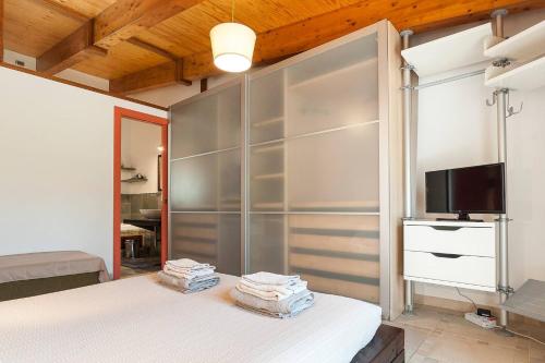 a bedroom with a bed and a tv on a wall at LA CESA Holiday House in San Felice Circeo