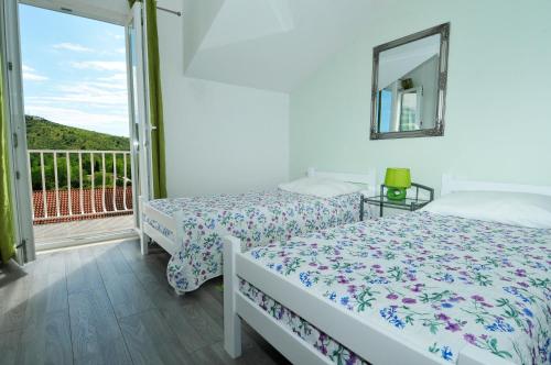 a bedroom with two beds and a balcony at Apartment Fiorenini 2 in Mlini
