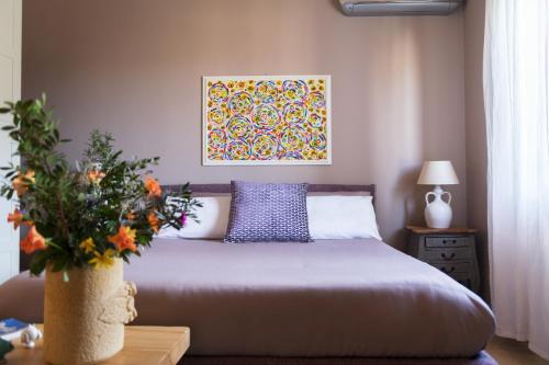 マンドゥーリアにあるTenuta Cardinaleのベッドルーム1室(ベッド1台付)が備わります。壁には絵画が飾られています。