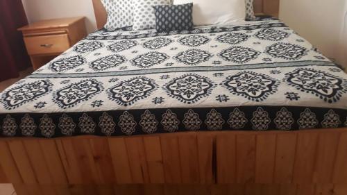 a bed with a black and white quilt on it at Personal Touch 1 in Nassau