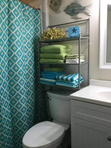 a bathroom with a toilet and a sink and towels at Spectacular Beach View! in Corpus Christi