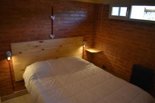 une chambre avec un lit blanc et une fenêtre dans l'établissement Anlupa Departamento, à El Bolsón