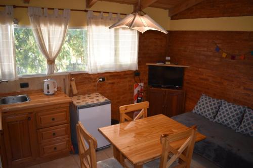 une cuisine avec une table et une petite cuisine avec un canapé dans l'établissement Anlupa Departamento, à El Bolsón