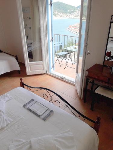 a bedroom with a bed and a view of a balcony at Odysseion Apartments in Vathi, Ithaka