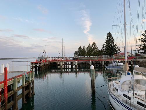 a dock with boats docked in the water at Boat Harbour Jetty B&B in Port Albert