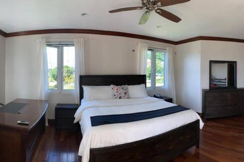 a bedroom with a large bed with a ceiling fan at Villa Xona in Castries